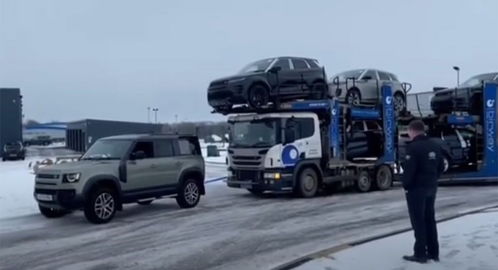 路虎卫士在冰上轻松地拖着一辆大型汽车运输车